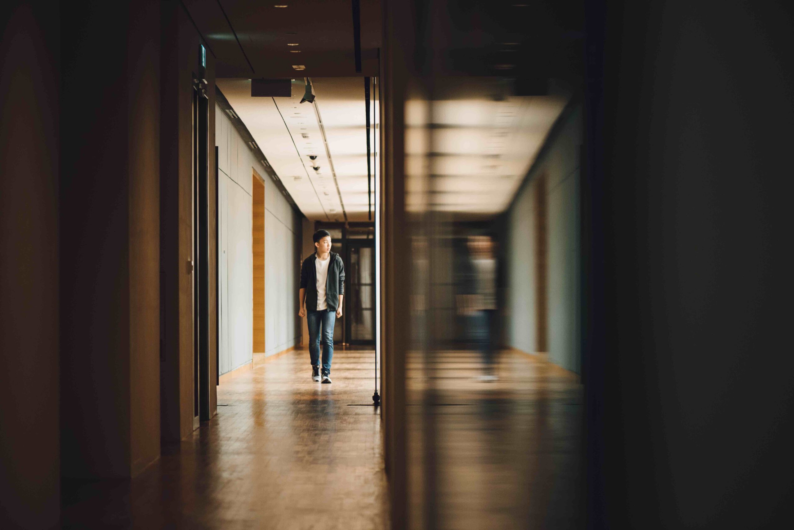 teenage boy walking school hallway